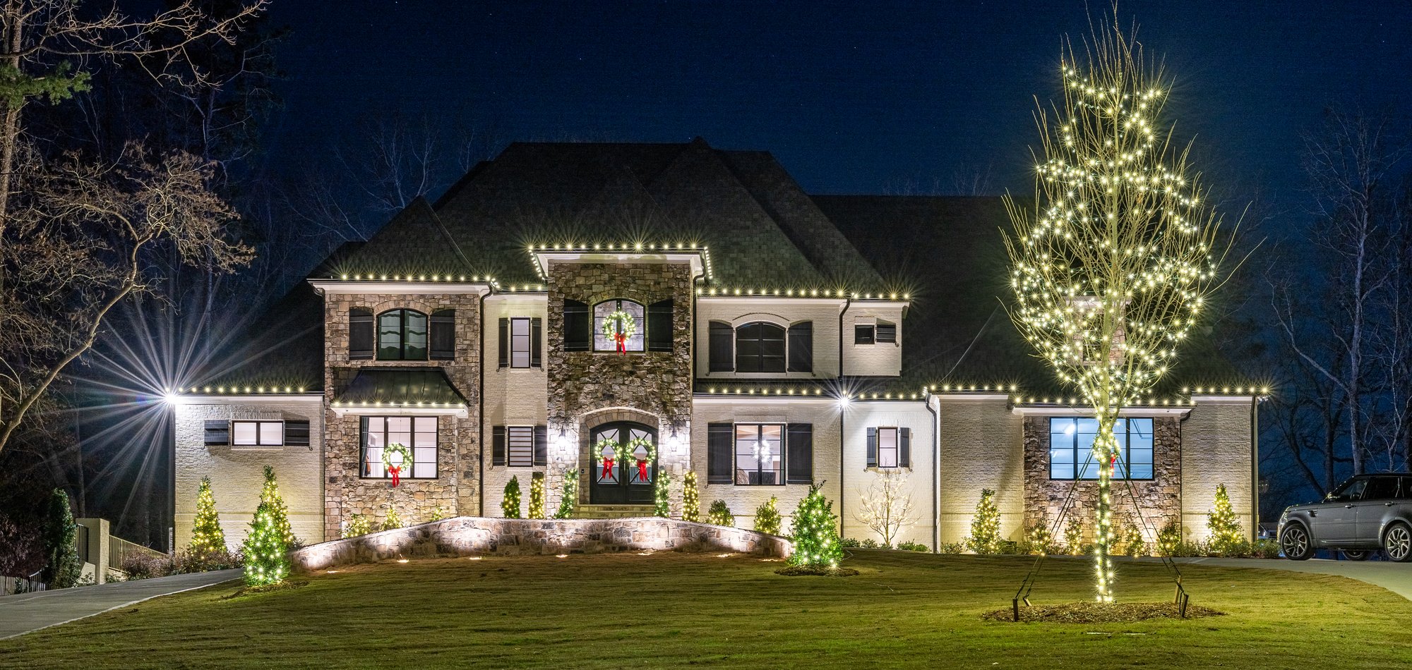 Warm white roofline, wreaths and a fully wrapped feature tree — holiday lighting by Shine in Cincinnati