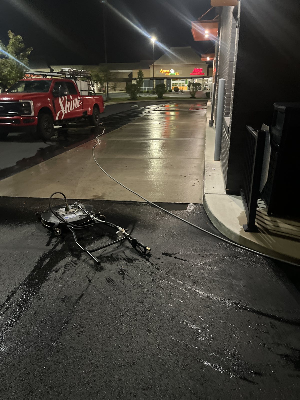 Overnight service at a retail center, crew and equipment on site — recurring site maintenance by Shine