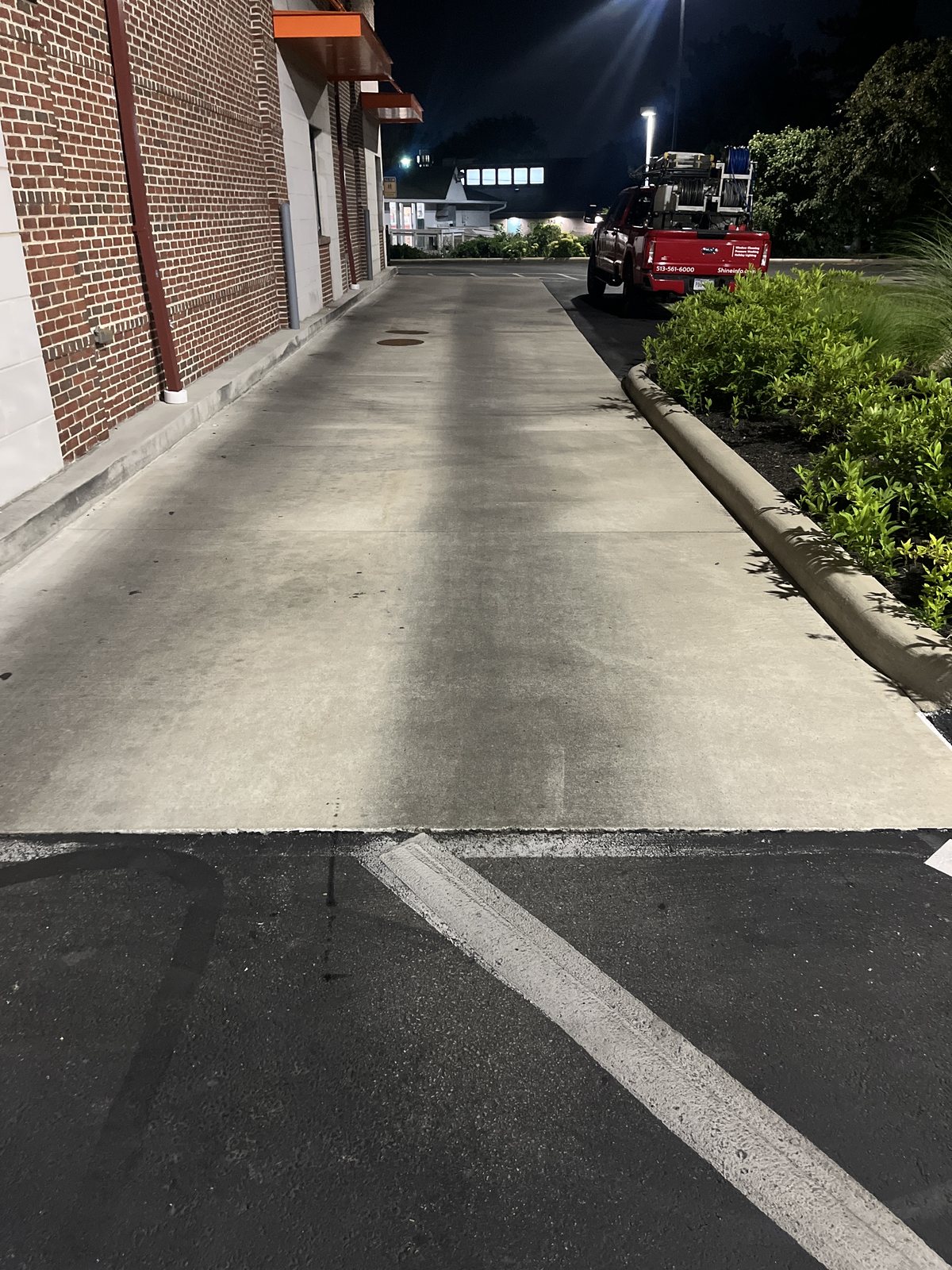 Sidewalk and entry cleaning along a retail storefront — recurring site maintenance by Shine